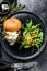 Delicious Burgers with blue cheese, bacon, marbled beef and onion marmalade, a side dish of salad with arugula and oranges. Black