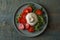 Delicious burrata cheese with tomatoes and arugula on grey wooden table, top view