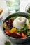 Delicious burrata salad with colorful cherry tomatoes and arugula on white wooden table, closeup