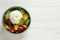 Delicious burrata salad with colorful cherry tomatoes and arugula on white wooden table, top view. Space for text