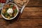 Delicious burrata salad with colorful cherry tomatoes, croutons and arugula served on wooden table, flat lay. Space for text