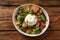 Delicious burrata salad with colorful cherry tomatoes, croutons and arugula on wooden table, top view