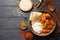 Delicious butter chicken with rice served on wooden table, flat lay.