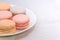 Delicious cake macaroons on plate on light background