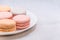 Delicious cake macaroons on plate on light background, close up