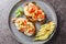 Delicious California Grilled chicken breast with mozzarella cheese, avocado and tomatoes close-up in a plate. horizontal top view