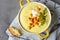 Delicious cauliflower soup with curry and cream in a bowl garnish roasted chickpea and arugula served with artisan bread.