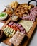 Delicious Charcuterie Board with snacks cheese, toast, ham, blue cheese, almonds, caramelized onions, green onion, honey, toast.