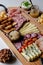 Delicious Charcuterie Board with snacks cheese, toast, ham, blue cheese, almonds, caramelized onions, green onion, honey, toast.