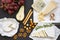 Delicious cheese with fruits, pretzels walnuts and bread sticks on dark background.