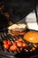 Delicious cheeseburger with tomatoes cooking on hot flaming grill. Barbecue. Restaurant