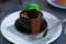 Delicious chocolate cake with pistachio French macaron on a plate