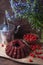 Delicious chocolate cake with sweet cherry, vintage kettle and bouquet of blue flowers on dark wooden background