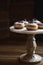 Delicious chocolate topped donuts on a vintage cake stand