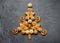 Delicious Christmas gingerbread men in the form of a Christmas tree. Christmas baking ingredients and supplies on dark background