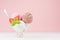 Delicious classic various flavor creamy ice cream scoops in bowl with strawberry slices, spoon, mint in modern pink color interior