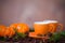 Delicious coffee in orange cups, small pumpkins and pine boughs