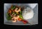 Delicious, colorful and healthy stir fry seafood dish with rice, shrimps, broccoli, carrots, cabbage and chili on a white plate