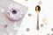 Delicious colorful purple donut with sprinkles  on stylish white table with confetti and vintage spoon, flat lay. Party concept.