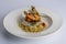Delicious combination of couscous with fish and shrimp served in a white ceramic dish