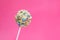 Delicious confectionery. Sweet cake pop decorated with sprinkles on pink background, closeup. Space for text