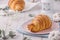 Delicious continental breakfast with fresh flaky french croissants, close up on the croissants. With white cotton flowers on a lig