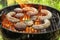 Delicious cooked sausages with patties and steak on barbecue grill outdoors