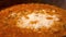 Delicious cooking and bubbling vodka sauce in a pan with Parmesan cheese