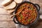 Delicious cowboy stew of beans with ground beef, bacon in a spicy sauce closeup in a bowl. horizontal top view