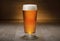 Delicious craft beer pint glass at brewery, imperial IPA pale ale, golden brown color