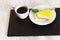 Delicious creamy cheesecake, lemon cheesecake and coffee on black rustic plate