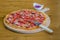 Delicious crepe pizza with sausage on wooden board with slicer