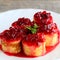 Delicious crepes rolls with red currant sauce on a white plate. Fried crepes rolls recipe. Yummy Easter breakfast idea