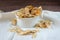Delicious crispy coconut chips with salted caramel in a white plate. Natural product made from coconut pulp.