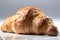 Delicious, crispy croissant on a light background. The croissant is carefully arranged to highlight its flaky layers.