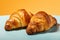 Delicious crispy croissants on vibrant turquoise and orange minimalistic background