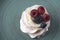 Delicious crispy meringue cake with fresh berries. Raspberries and blueberries in the famous dessert of Anna Pavlova.