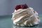 Delicious crispy meringue cake with fresh berries. Raspberries and blueberries in the famous dessert of Anna Pavlova.