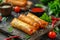 Delicious Crispy Spring Rolls on Dark Slate with Fresh Herbs, Sauce, and Cherry Tomatoes Asian Cuisine Concept