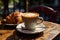 Delicious croissant and cup of coffee on a dark background