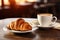 Delicious croissant and cup of coffee on wooden table