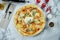 Delicious and crunchy Italian pizza with burrata cheese and other cheeses, red sauce. in a plate on a marble background. Top view