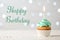 Delicious cupcake with burning candle and greeting HAPPY BIRTHDAY