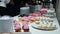 Delicious cupcakes on candy buffet, people takes food from smorgasbord