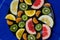 Delicious cut bright sweet acidic citrus grapefruit orange Mandarin sweetie kiwi in a large black plate in the middle of the image