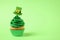 Delicious decorated cupcake on green background, space for text. St. Patrick`s Day celebration