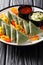 Delicious deep fried green samosa with sauces and peppers closeup on a plate. vertical