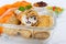 Delicious delicate pancakes with cottage cheese and raisins in a glass container on a white wooden background