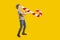 Delicious dessert. A guy with a funny face. A cute boy with a huge candy on a yellow background pretends to play the saxophone
