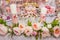 Delicious desserts at the wedding candy bar in the buffet area: decorated candles, rosebuds, ribbons, macaroons, strawberries in